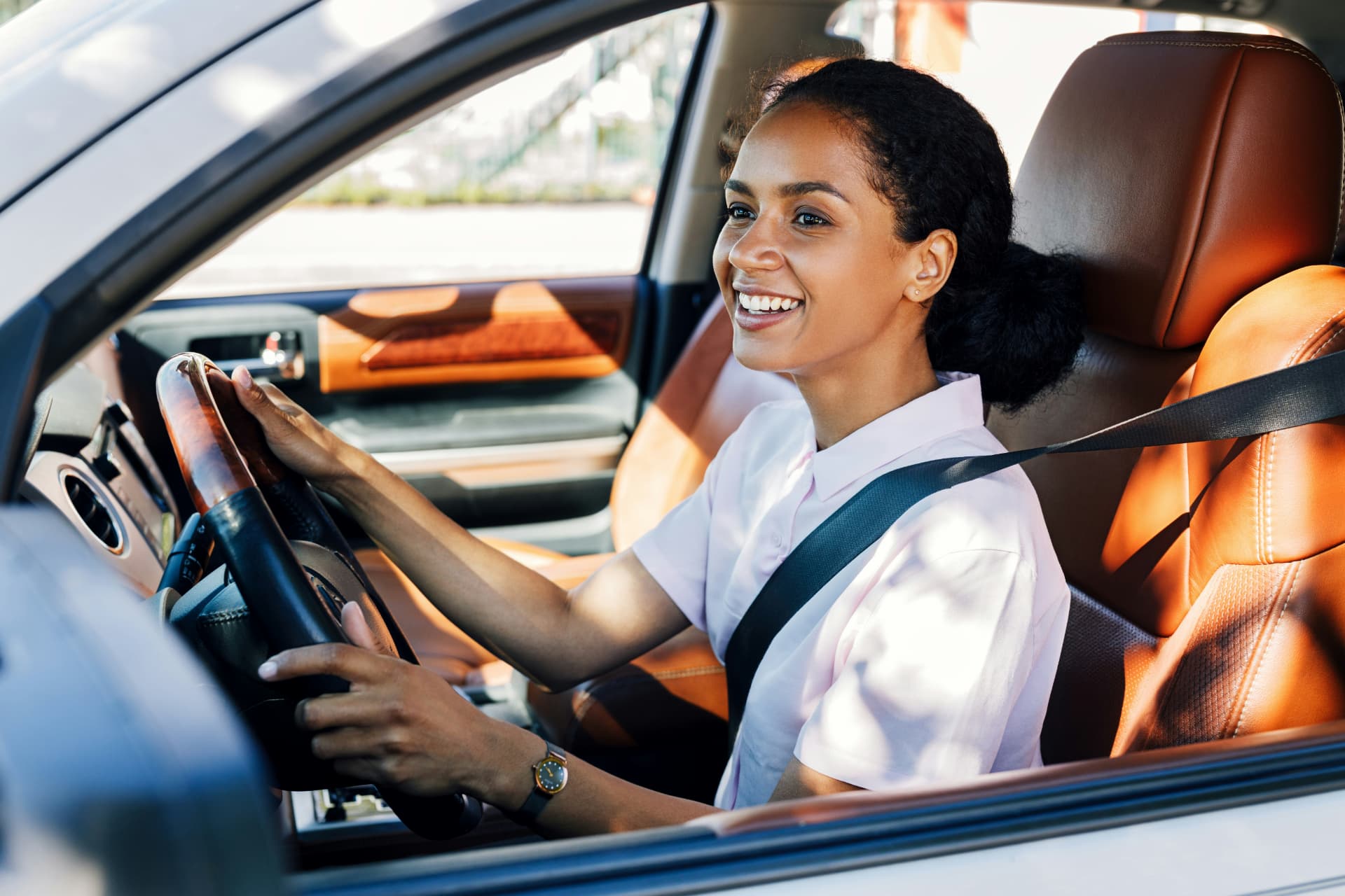 Jeune conductrice souriante au volant pendant une leçon de conduite